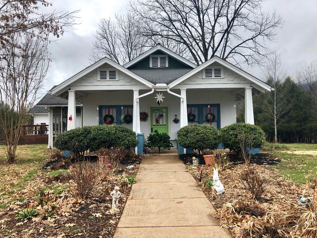 Front of a white craftsman bungalow with a covered porch