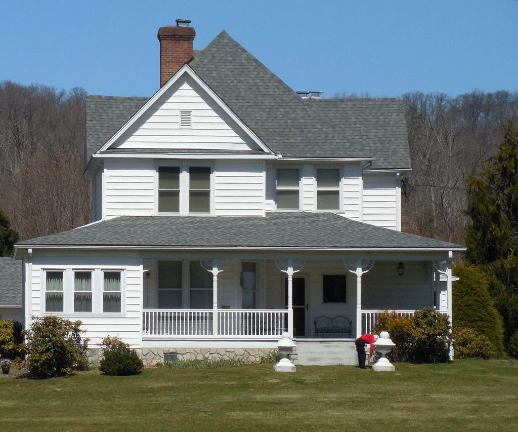 White Victorian farmhouse with a wraparound porch