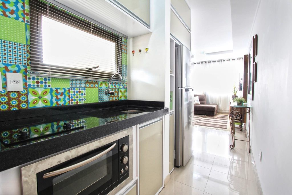 Remodeled kitchen with patterned tile and black countertops