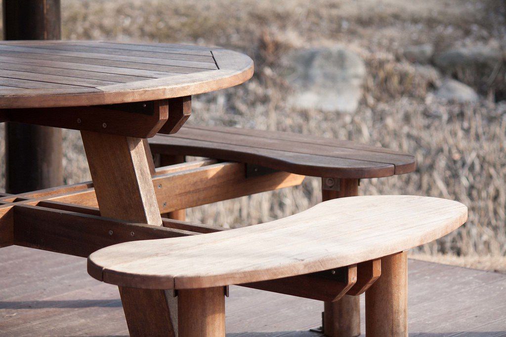 Round wooden garden table with curved benches